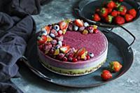 Vegan raw cheesecake with blueberry, cherry, match