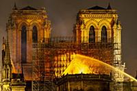 Firefighters douse flames from the burning Notre D