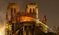 Firefighters douse flames from the burning Notre D