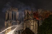 Firefighters douse flames from the burning Notre D