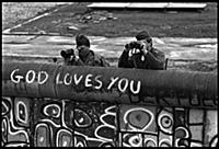 East German border guards watch protestors in the 