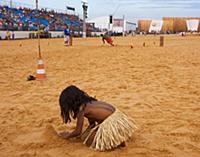 Indigenous girl plays in the sand as the spear thr