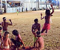 Indigenous children play on the sidelines during t