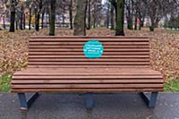 A sign in Russian on a park bench about 'Keeping a