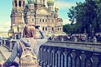 Young woman backpacker takes a picture of Church o