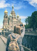 Young woman backpacker takes a picture of Church o