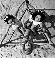 Three women having fun on the beach in the 1960s