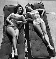 Women sunbathing lying on sunbeds