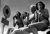 Four young women enjoying the sun sitting on the r