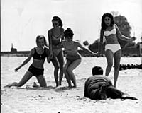 four women having fun on the beach in the 1960s