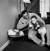 Ray Ellington, 1915-1985, at home in London with h