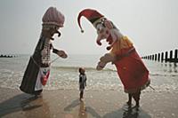 A giant Punch and Judy meet young fan on the beach