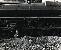 A young black man working as an ash pit cleaner wi