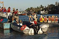 Tourists on municipal dock boarding zodiac boats, 