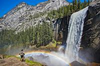 Hiker near waterfall and rainbow, Nevada Fall, Yos