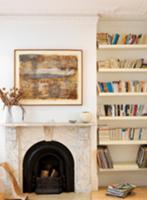 Open fireplace with marble surround and bookcase i