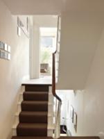 Dark stair runner on white-painted wooden stairs i