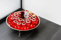 Tray with red tea light holders on grey tiled floo