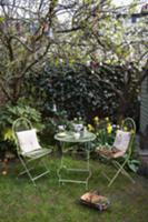 Garden table with two chairs beneath tree with Eas