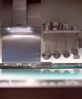 Stainless steel pots hanging beneath kitchen shelf