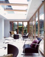 Black, retro armchairs next to glass wall in livin