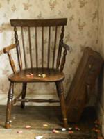 Antique wooden chair and old suitcase in corner