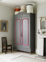 Hatboxes on old wooden cupboard in room with firep