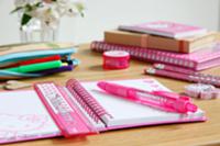 Pink writing materials on child's desk