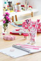 Various pink writing materials on table