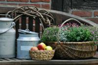 Old milk cans, fruit basket & basket of flowers on