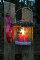 Storm lamp with wreath of heather hanging on woode