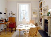 Living space with bureau, table & woven chairs in 