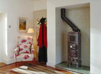 Foyer with old coal-fired stove, armchair & coat r