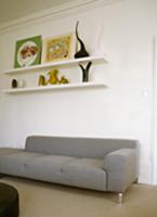 Shelves with objet d'art and pictures above plain,