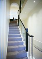 Grey runner and glass balustrade in stairwell with