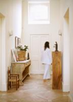 Woman walking down hallway with rustic wooden furn