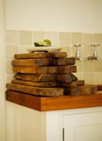 Wooden chopping boards stacked on kitchen work sur