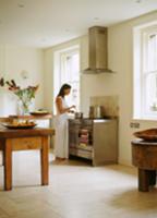 Woman seasoning food in plain kitchen with rustic 