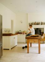 Boy sitting on wooden table in plain kitchen