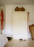 Wicker baskets on white-painted rustic wardrobe in