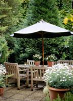 Dining area on terrace with wooden chairs beneath 