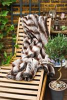 Garden lounger with fur blanket, olive tree and ga