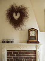 Heart-shaped wicker wreath on wall and antique clo