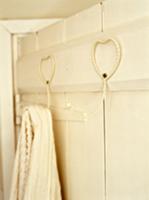 Heart-shaped, metal hooks on wooden wall