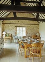 Rustic dining area in open-plan room with stone wa