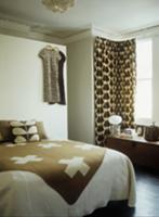 Brown and white throw on double bed and curtain on