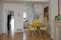 Light green shell chairs at wooden table in open-p