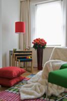 Fur throw on armchair and nest of tables in corner