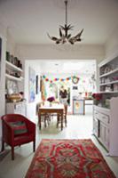 Red armchair and kitchen dresser in foyer with wid