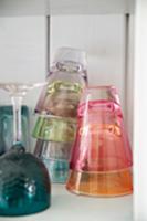 Colourful drinking glasses stacked on shelf